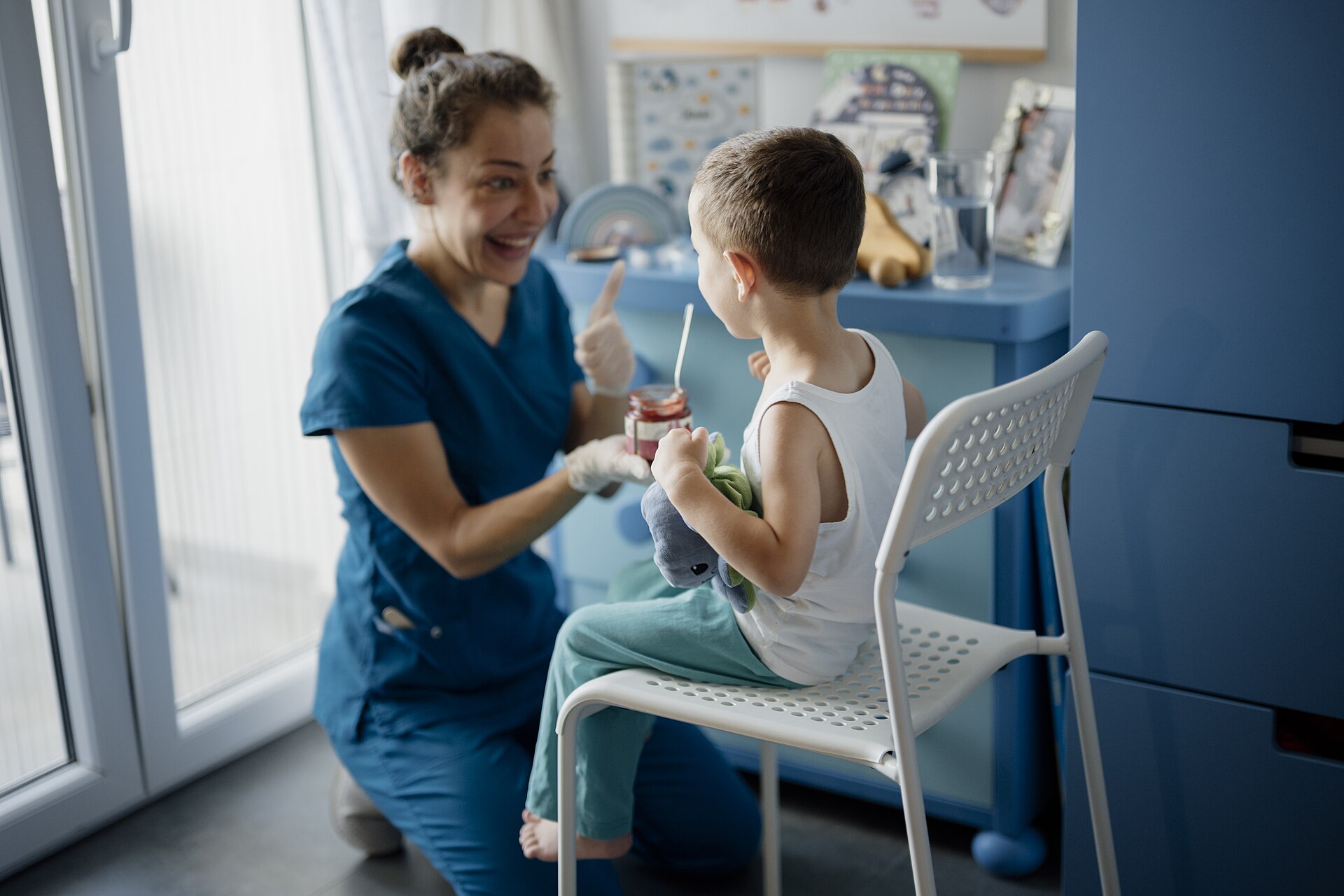 A child sitting with a smiling dental professional giving a thumbs up